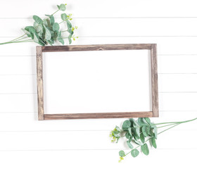 frame of rough wood on a light background with eucalyptus branches