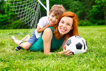 Image of family, mother and son playing ball in the park