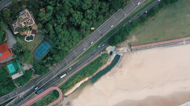Aerial View Of Parachuter Gliding Over Highway And Residential Area Toward Beach