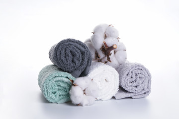 Bath accessories. Hygiene products. Multi-colored bath towels with a flower of cotton on a white background.