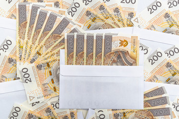 Background made of the front side of a Polish PLN 200 banknote inserted in a white envelope, concept of giving bribes and bribery.