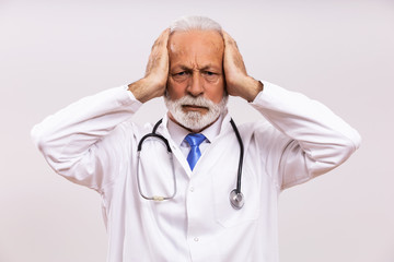 Image of  overworked senior doctor on gray background.