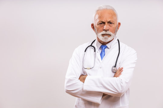 Image of  angry senior doctor on gray background.