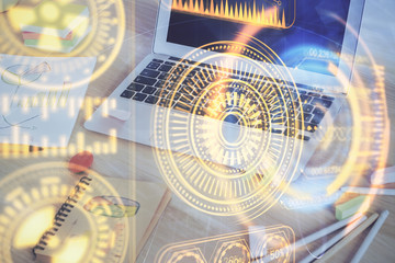 Computer on desktop in office with technology theme hologram. Multi exposure. Tech concept.