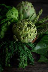 Obraz premium Artichokes, herbs, salt and pepper on wooden table