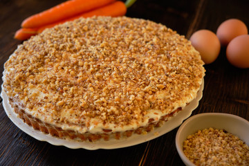 Carrot cake and fresh carrot on wooden table
