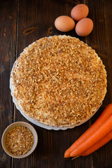 Carrot cake and fresh carrot on wooden table