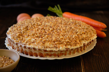 Carrot cake and fresh carrot on wooden table