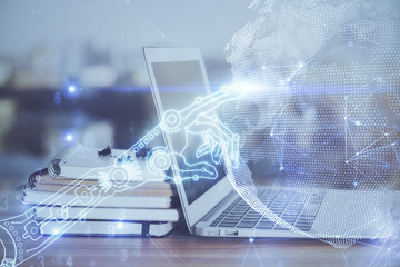 Computer on desktop in office with technology theme hologram. Multi exposure. Tech concept.