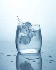 Drop of ice in a glass of water. Pure spring drinking water, drops of water, splash