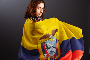 Happy Ecuadorian woman smiling and posing with a flag - isolated over a gray background