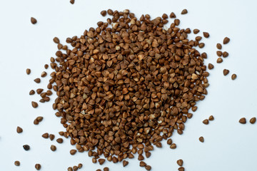 heap of buckwheat on a white background. place for text. raw cereal grains