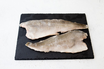  frozen fish, filet on a black board