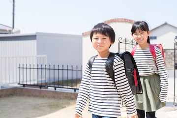Obraz premium 家に帰る小学生の男の子と女の子