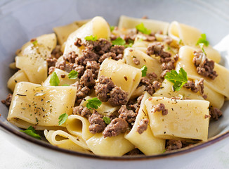 Pasta Calamarata with minced meat in blue bowl. Italian cuisine.