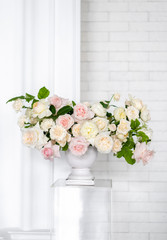 Bouquet of white roses in a vase with raspberry leaves. Dressing at a wedding.