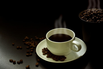 Coffee beans in a white coffee cup in a black background