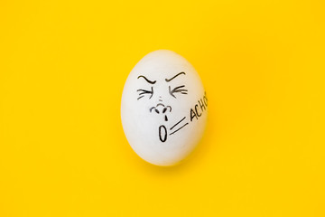drawing face on egg isolated on yellow background