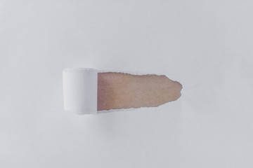 Torn white paper with opening showing brown background