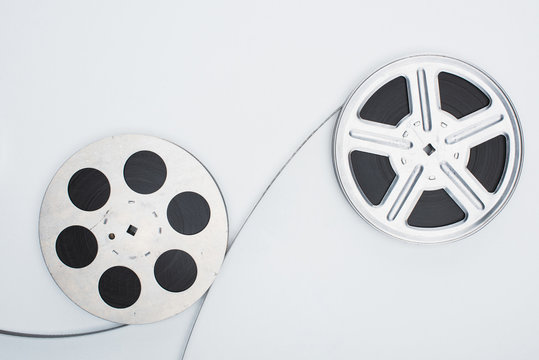 top view of film reels and film strip on white background