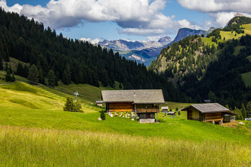 Fototapeta na wymiar Chalets in Seiser Alm with Dolomites in the Background