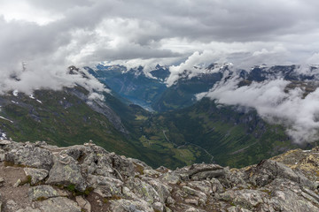 Fototapeta na wymiar View to Geiranger fjord and eagle road in cloudy weather from Dalsnibba mountain, serpentine road, Norway, selective focus.