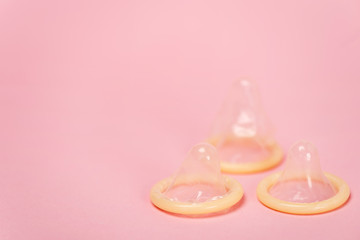Close up view of condoms on pink background with copy space