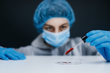 Forscher tropf Blut mit einer Pipette in eine Petrischale 