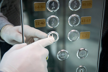 male hand in protective glove virus coronavirus presses button lift