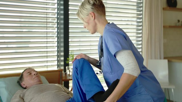 Healthcare worker and paralysed senior patient in hospital, physiotherapy.