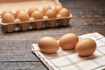 Organic  eggs in carton box on a black wooden table, selective focus.