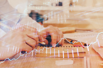 Multi exposure closeup hands with stock market forex graph.