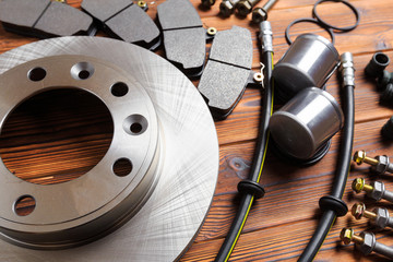 brake parts on wooden background  brake pads, disc, brake hose, guides, cylinders- Image