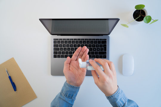 Male sanitizes hands at modern workspace during coronavirus quarantine 