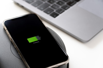Close up of a smartphone that is being charged on wireless charger