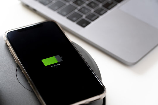 Close up of a smartphone that is being charged on wireless charger