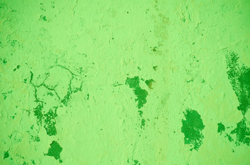 Fragment of old house wall close-up. Green background. Peeling plaster on concrete surface. Cracks in paint. Copy space. Place for text. Selective focus image.