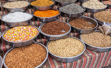 Assortment of different salted and sweet organic nuts and sunflower seeds in metal bowls standing on counter of street market in Turkey. 