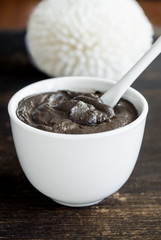 Black volcanic clay in the white bowl. Diy facial mask and body wrap recipe. Natural beauty treatment and spa. Copy space.