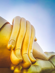 Close up hand of big Buddha statue with blue sky at Wat Tha Muang Thailand. The most specifically...