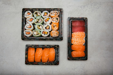 Stock photo of maki and nigiri sushi on takeaway trays and eat at home.
