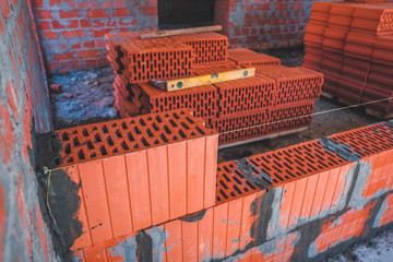 Concept of construction. Brickwork of the wall, correct laying of red bricks for a reliable wall of...
