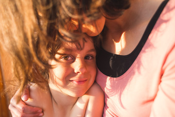 Obraz premium Portrait of a child hugging a mother, a boy spends time with mom, a woman gently hugs her son.