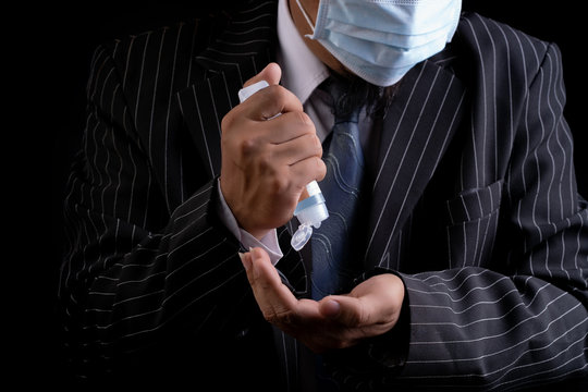 Asian Man wearing facial hygienic mask  is holding  alchol jel bottle  for hand washing on black background.Anti-virus and Anti-COVID 19.Coronavirus.