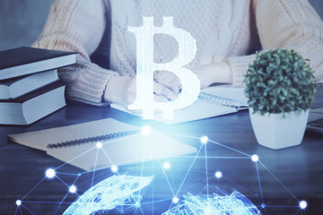 Cryptocurrency hologram over hands taking notes background. Concept of blockchain. Multi exposure