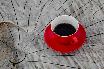 Czerwona filiżanka kawy na starym, drewnianym stole