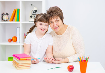 Mom deals with girl with Down syndrome, concept of home schooling and classes. Mother and daughter play together. World Down syndrome