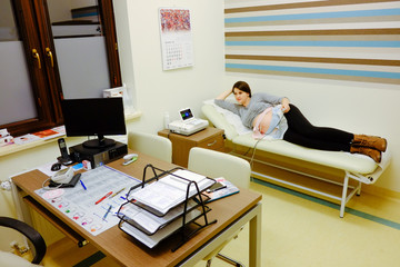 Woman at doctor office whit ctg or ecg.  Ctg pregnancy at hospital. 