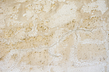 Light building background. gray wall of old house closeup. White peeling plaster. Cracks on the surface of building or fence. City building concept. Copy space. Place for text. Selective focus image.