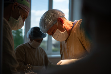 Kiev, Ukraine - 11 march 2016: Documentary during the surgery at the hospital. Concentrated surgeon doing operation under operation light